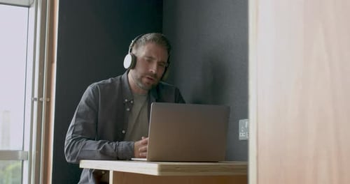 Business man on video call talking in coworking office booth
