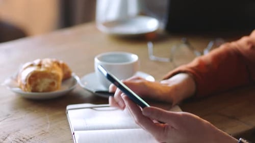 Coffee shop, smartphone and hands with notebook for creative inspiration