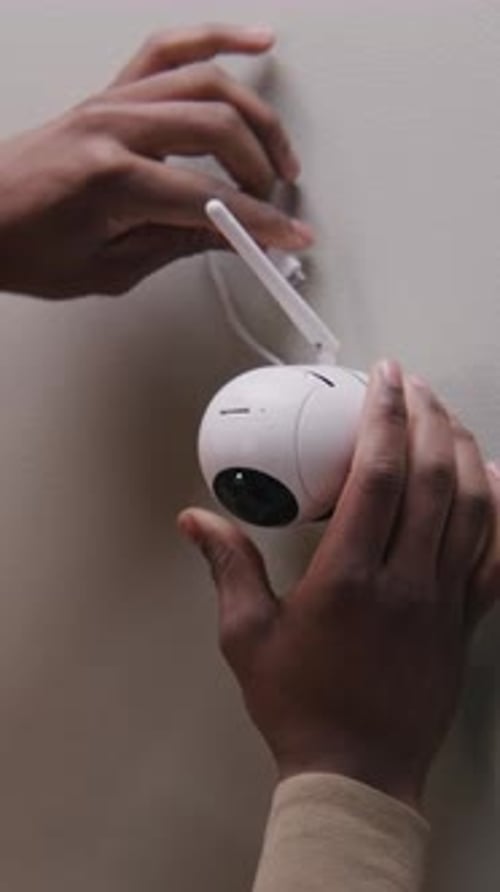 African American Man Puts Security Camera on Wall
