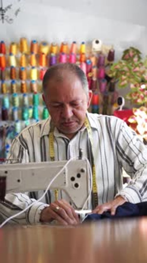 Mature Latin man sewing in his tailor workshop