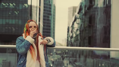 Woman with Dreadlocks Drinks Coffee in the City
