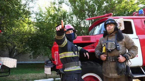 Firefighters Pointing Towards Incident Next to Firetruck