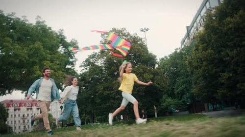 Family Running With Kite In Park