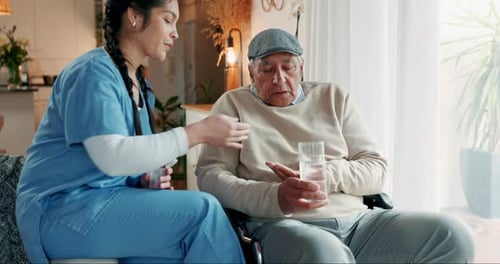 Woman Giving Medication to Senior Man at Home
