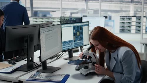 Woman Using Microscope in Office Reviewing Semiconductor Substrates