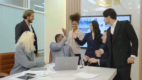 Diverse Team Celebrates Success in Modern Office