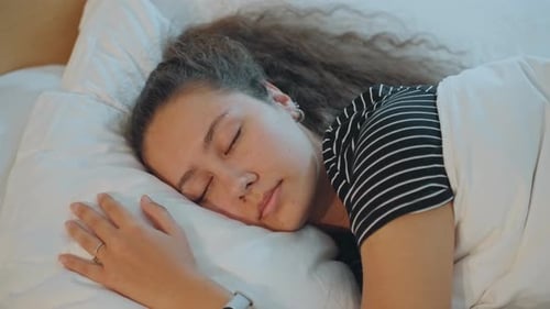 Woman Sleeping Soundly on Pillow in Indoor Home