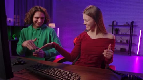Excited Young Adults Gaming Together at Home