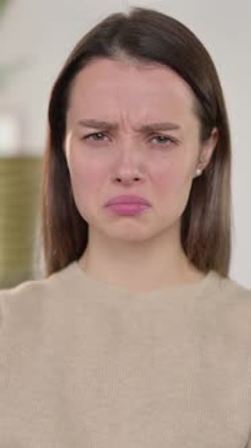 Sad Young Woman Looking at Camera Indoors
