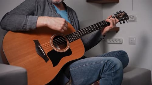 Man Plays Acoustic Guitar and Sings Indoors