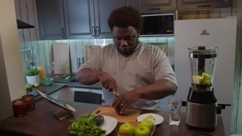 Young Adult Prepares Healthy Smoothie in Kitchen