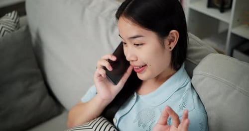 Woman Talking on Phone While Sitting on Couch