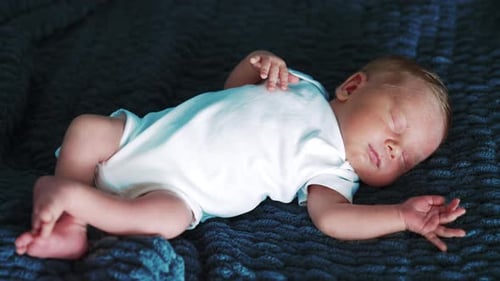 Infant Sleeping Peacefully on Blue Blanket Indoors