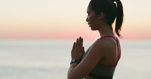 Woman Meditating on Beach at Sunrise
