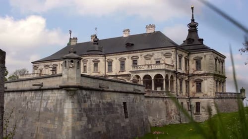 Old Castle Made From Gray Stones. Birds Fly in Blue Cloudy Sky