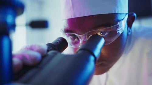 Wissenschaftler analysieren Probe mit Mikroskop im Labor