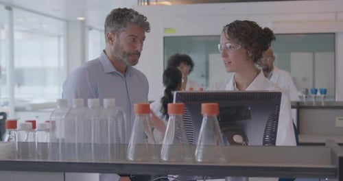 Scientists Collaborating on Computer in Bright Lab