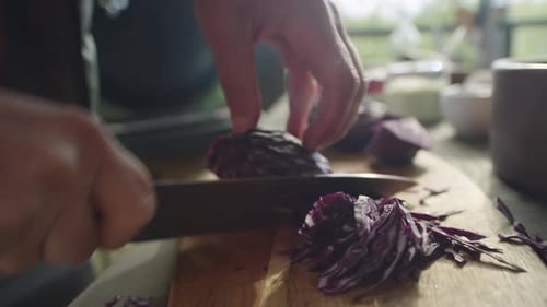 Männliche Hände zerkleinern Rotkohl