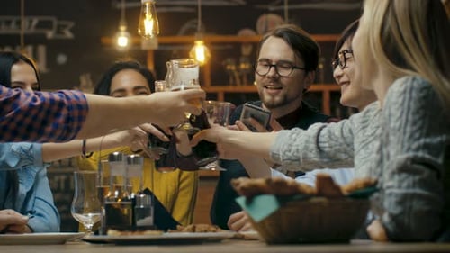 Friends Cheers Drinks at Night Gathering in Restaurant