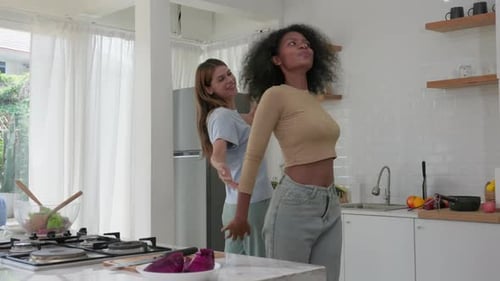 Two Women Friends Dancing in Kitchen Together