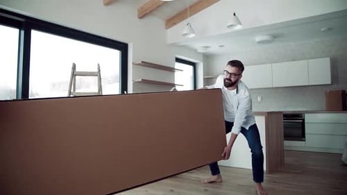Couple moving a large box into new house