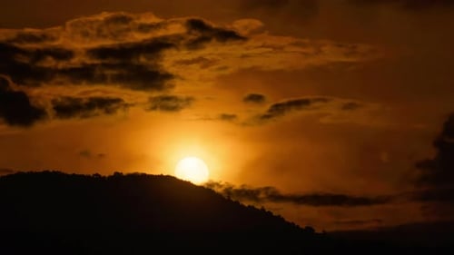 Timelapse of dramatic sunrise with orange sky in a sunny day.