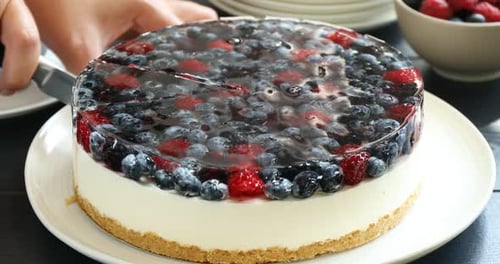Cutting a Delicious Berry Cheesecake with Gelatin Topping