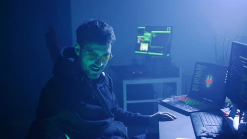 Um programador focado está imerso em uma sala escura cercada por tecnologia de ponta