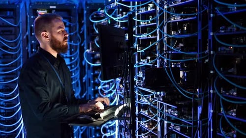 Man Working in a Blue Lit Server Room