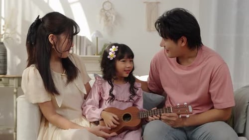 Family Enjoys Playing Ukulele Together in Living Room