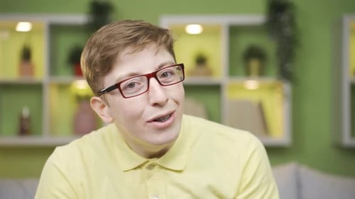 Close-up playful young man dancing looking at camera.