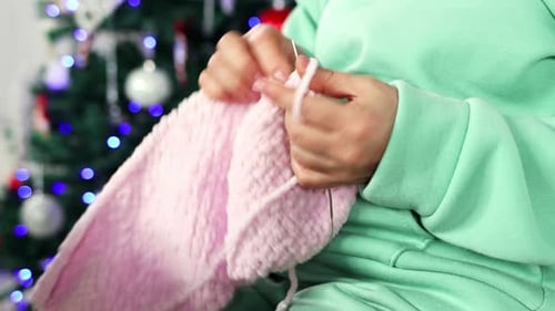 Hands Knit Pink Fabric Near Christmas Tree