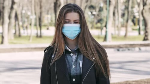 Young Woman Wearing Protective Mask in Empty City Park