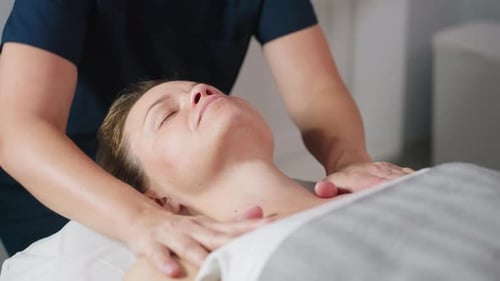 Wellness Technician Massaging Neck Then Shoulders in Bright Spa Room