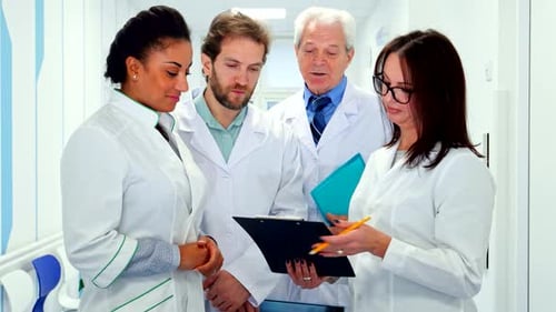 Medical Team Reviews Patient Information in Hospital Corridor