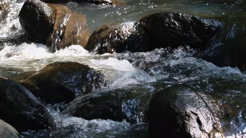 Water Flowing Through Rocks making water sounds and white water bubbles; 4K long footage perfect for