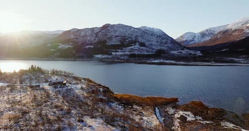 Winter Glow on Lofoten Solitary House By the Fjord with Snowy Mountains Drone View of Seawater with