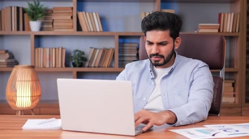 Man Frustrated by Laptop Closes it at Desk