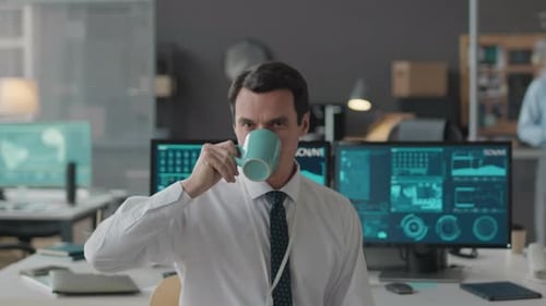 Portrait of Cybersecurity Officer Drinking from Mug at Workplace