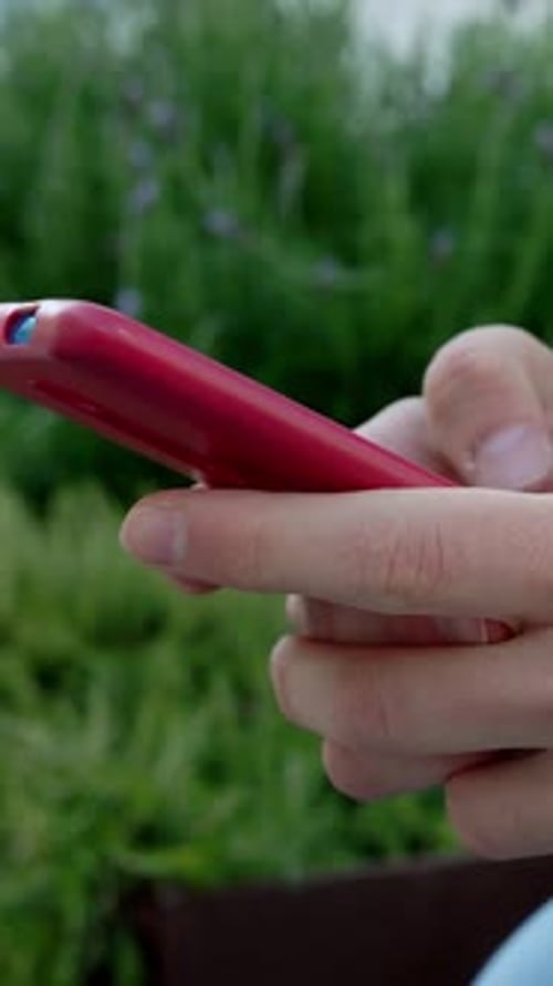 Hands Using Cell Phone Outdoors