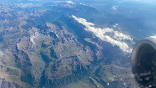 Stunning footage of aerial view above clouds from an airplane window on high mountains