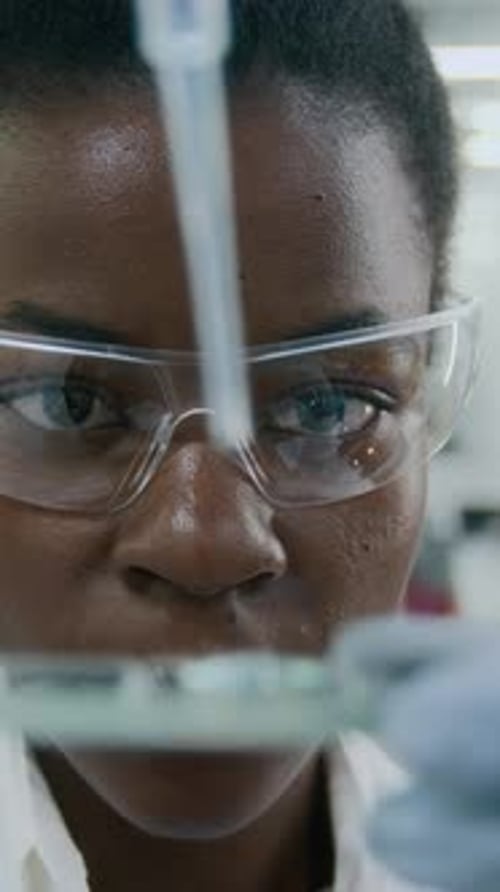 Close-up of Technologist Dripping Blue Solution on Slide with Pipette