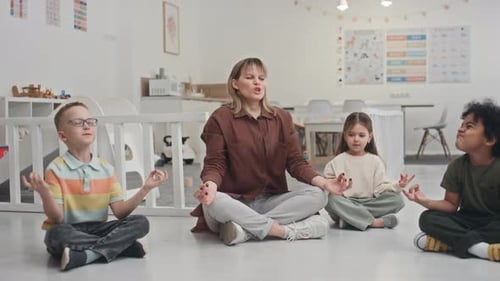 Children Meditating with Teacher in Bright Classroom