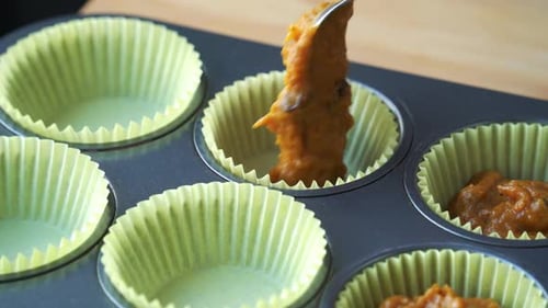 Putting in mixed wet flour batter for vegan pumpkin muffins using real roasted pumpkin in bowl healt