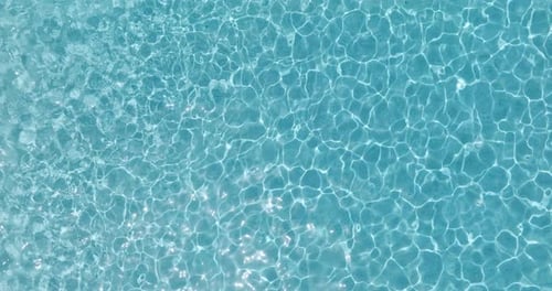 Blue Water in the Swimming Pool with Light Reflections