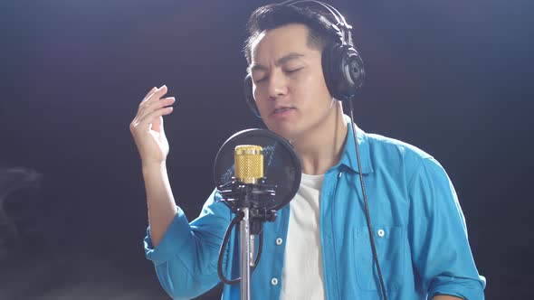 Asian Man With Headphone Rapping Into A Condenser Microphone On The ...