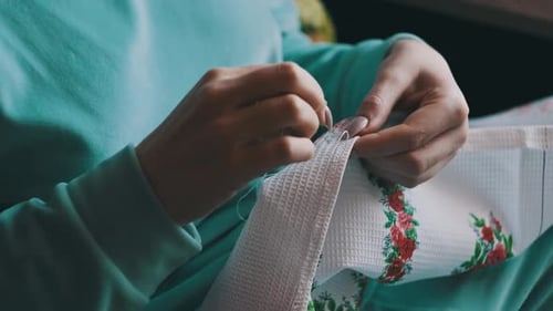 Adult Hands Embroidering Floral Pattern