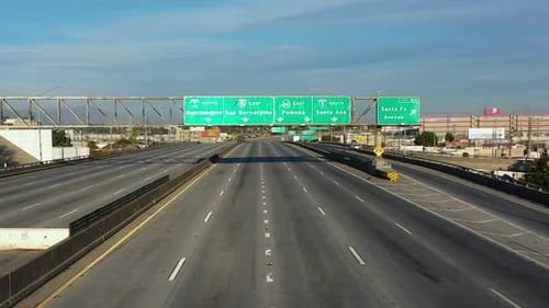 Drone shot toward freeway signs at the closed Interstate 10 in sunny Los Angeles