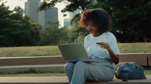 Portrait of African American Woman Paying Online with Credit Card and Laptop
