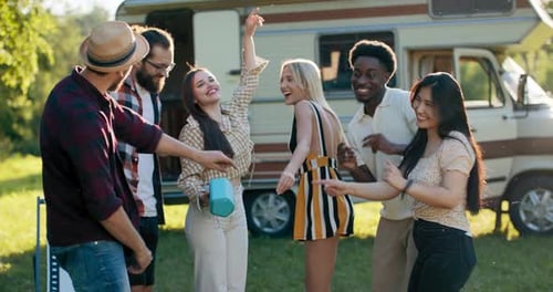 Friends Dancing to Music Outdoors by Camper